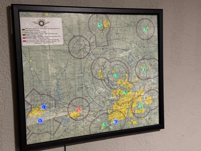 A framed Hotshot Map mounted on a wall, lit with current flight conditions